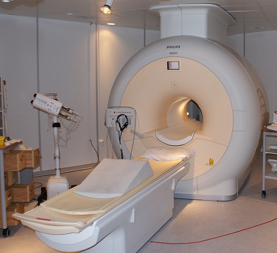 A hospital MRI scanner with its patient table extended.