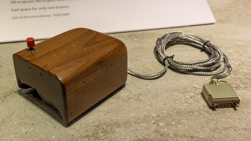 A wooden box with one button and a cord: a replica of the first computer mouse.